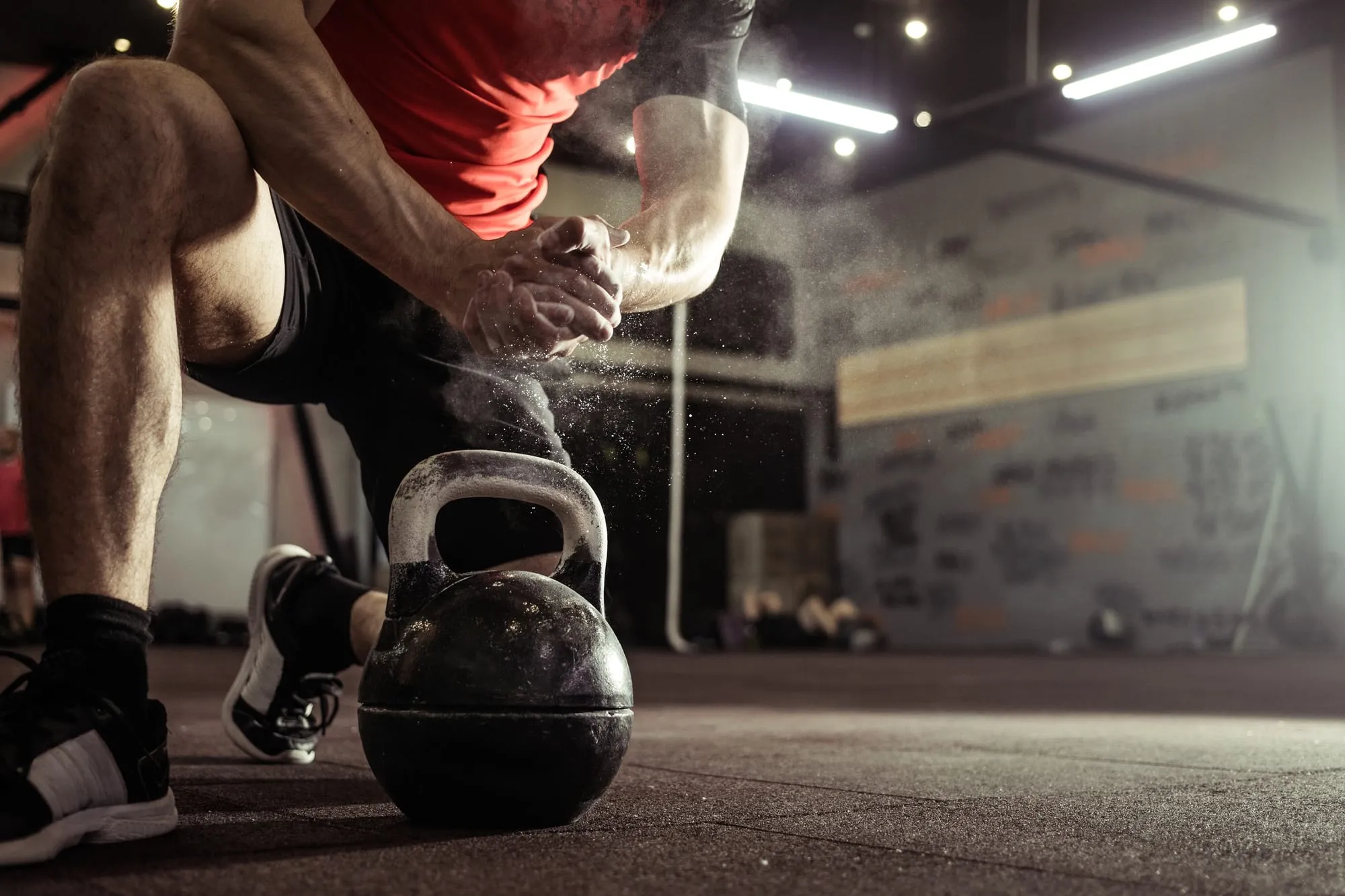 Sportif se préparant à travailler avec un kettlebell dans une salle.